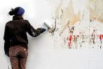 Mujer pintando una pared